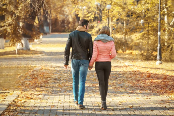 Young couple walking in park on autumn day Stock Photo