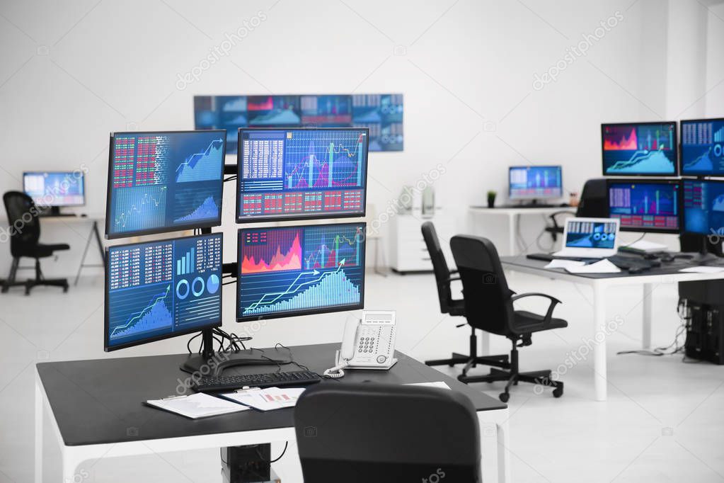 Monitors with stock data on table in office