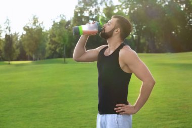 Protein içeceği açık havada içki sportif genç adam