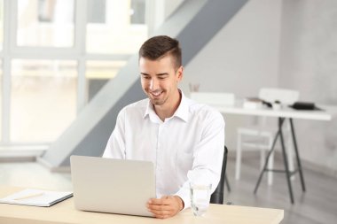 Ofiste dizüstü bilgisayar ile çekici bir adam