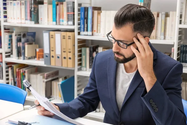 Mann arbeitet mit Dokumenten am Tisch im Archiv — Stockfoto