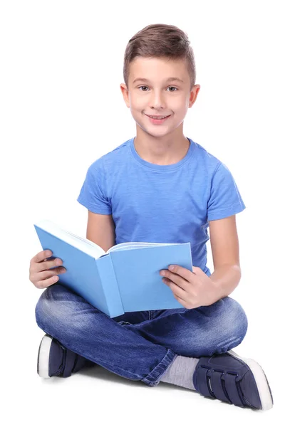 Niedlicher kleiner Junge liest Buch auf weißem Hintergrund — Stockfoto