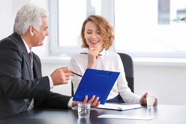 Älterer Mann berät junge Frau im Amt — Stockfoto