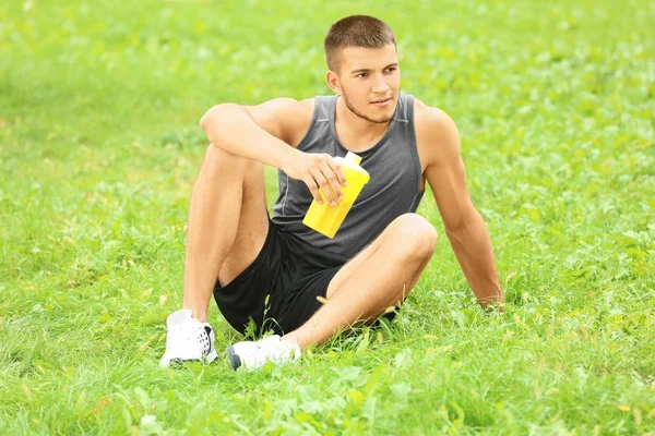 Bello giovane uomo con frullato proteico — Foto Stock