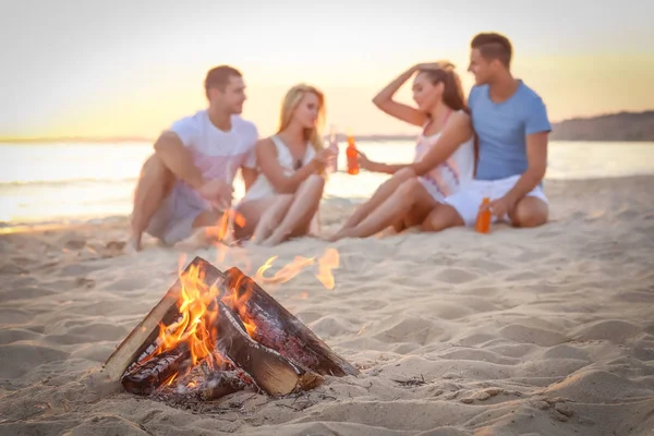 Falò sulla spiaggia e persone offuscate sullo sfondo — Foto Stock