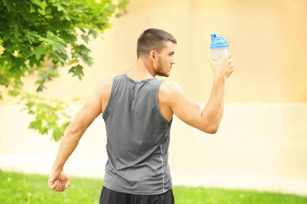 Schöner junger Mann mit Proteinshake — Stockfoto