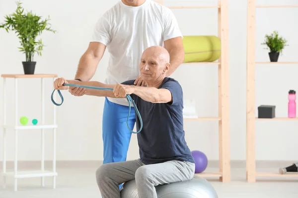 Fysiotherapeut werkt samen met patiënt in kliniek — Stockfoto