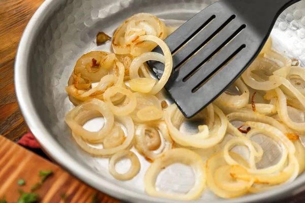 Panela com espátula e cebola frita — Fotografia de Stock
