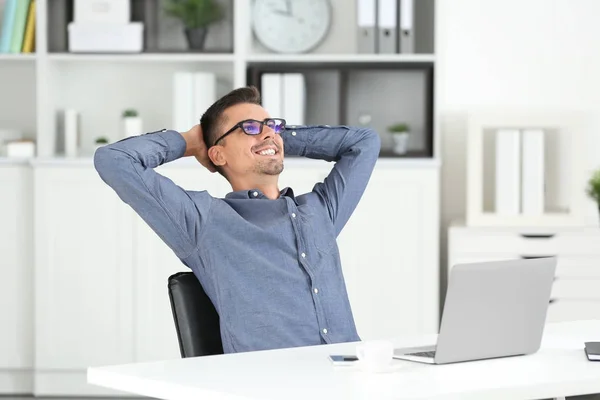 Attraktiver Mann mit Laptop im Büro — Stockfoto