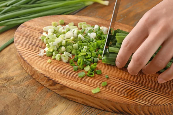 Donna che taglia cipolla verde fresca — Foto Stock