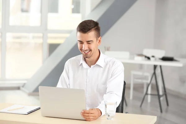 Hombre atractivo con portátil en la oficina — Foto de Stock