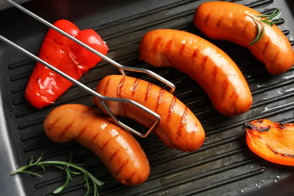 Salsichas fritas na panela de grelha — Fotografia de Stock