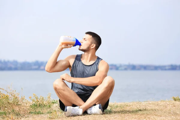 Joven guapo con batido de proteínas — Foto de Stock