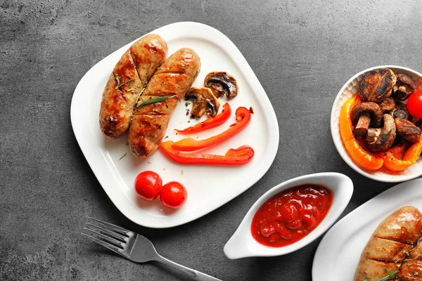 Состав с жареными колбасами, овощами и соусом — стоковое фото