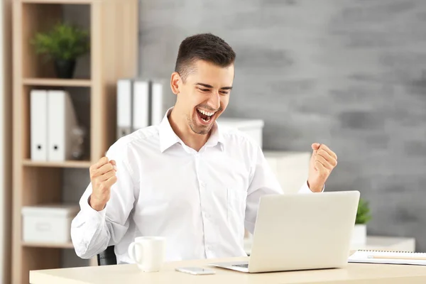 Emotionele man met laptop in kantoor — Stockfoto