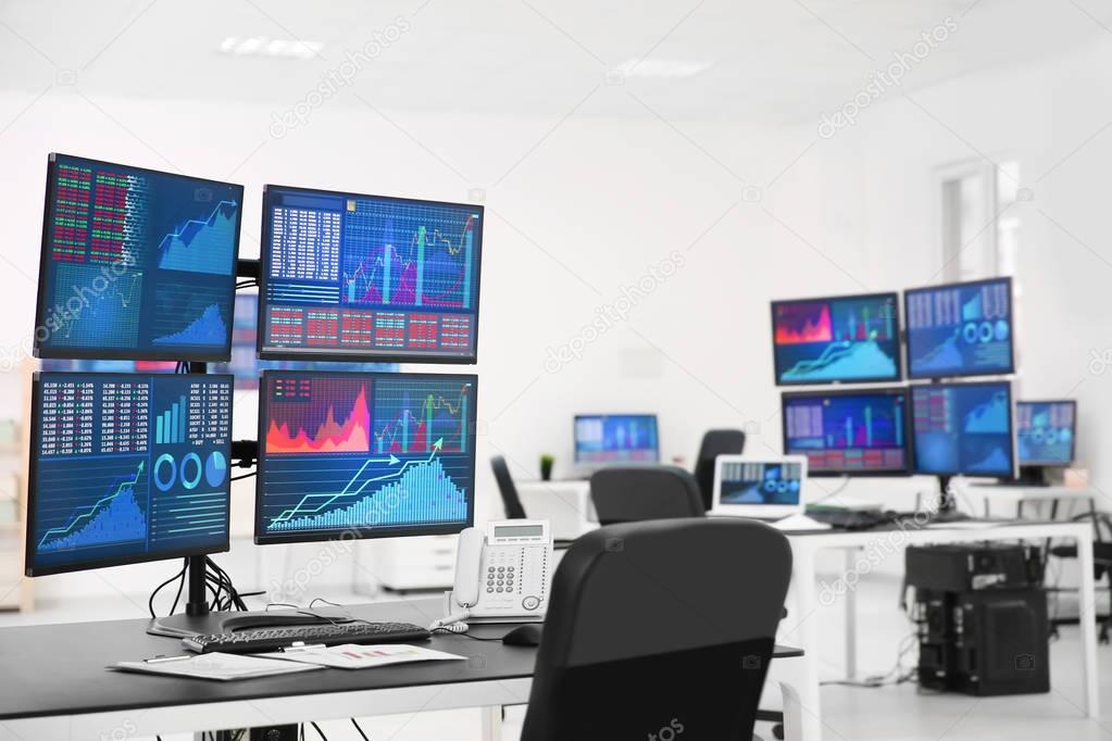 Monitors with stock data on table in office