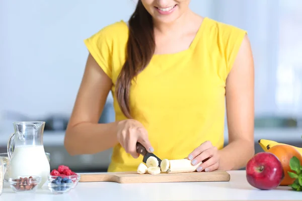 Молодая женщина режет банан — стоковое фото