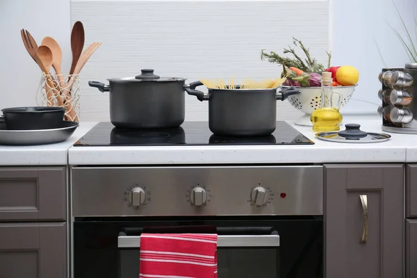 Cooking utensils on electric stove — Stock Photo, Image