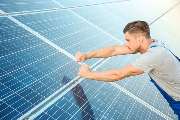 Junge Arbeiter installieren Sonnenkollektoren im Freien — Stockfoto