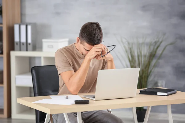 Hombre cansado con portátil — Foto de Stock