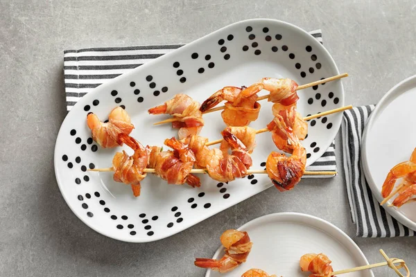 Plate with skewered shrimps wrapped in bacon — Stock Photo, Image