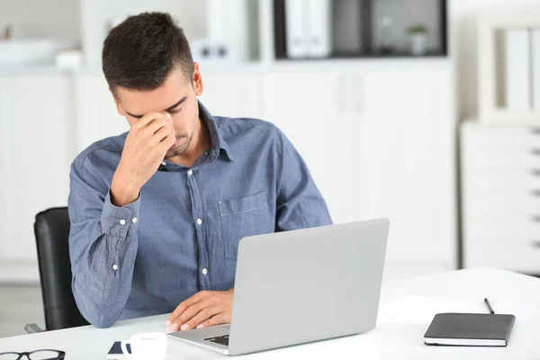 Homem cansado com laptop — Fotografia de Stock