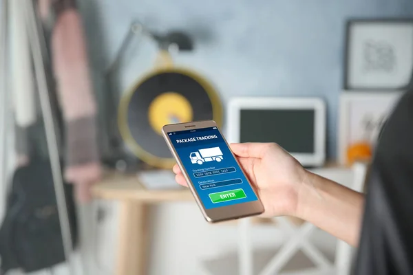 Woman tracking parcel with help of smartphone app at home — Stock Photo, Image