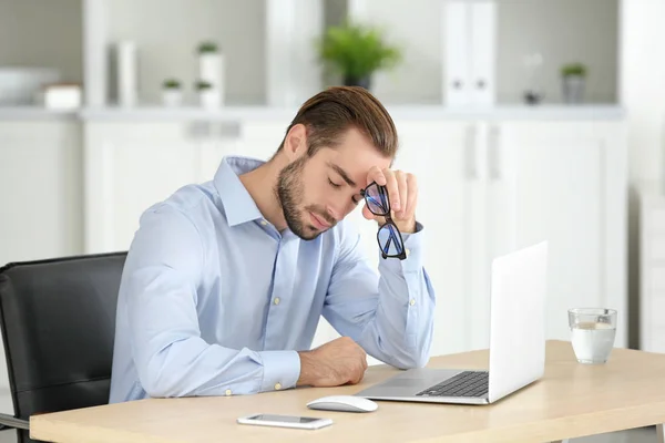 Homem cansado com laptop — Fotografia de Stock