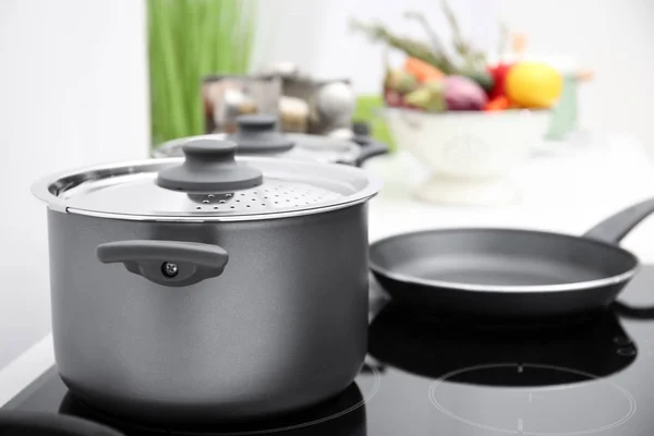 Cooking utensils on electric stove — Stock Photo, Image