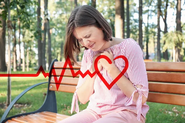 Woman suffering from heart attack outdoors