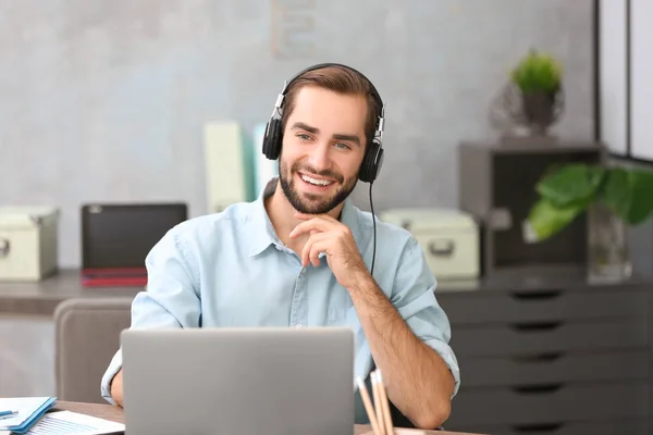 Hombre joven usando el ordenador portátil — Foto de Stock