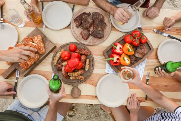Jongeren met barbecue aan tafel — Stockfoto