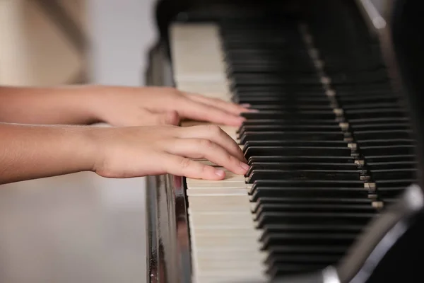 Маленькая девочка играет на пианино в помещении, крупным планом — стоковое фото