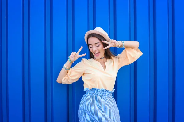 Menina hipster atraente posando perto da parede de cor — Fotografia de Stock