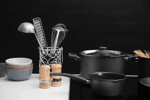 Different cooking utensils on electric stove — Stock Photo, Image