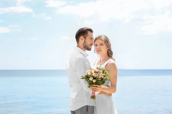 Couple nouvellement marié au bord de la mer — Photo