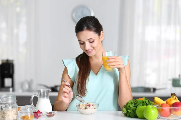 Young woman eating oatmeal — Stock Photo, Image