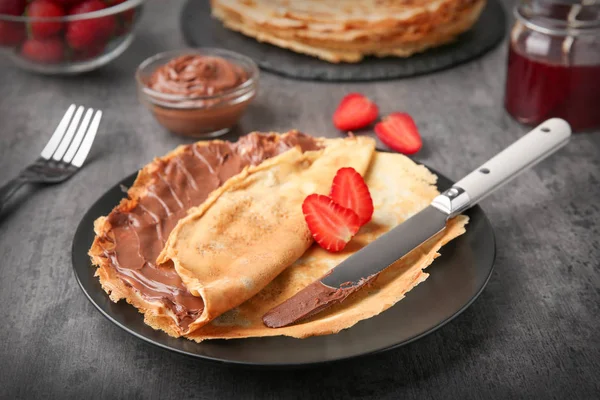 Assiette avec de fines crêpes à la pâte de chocolat et baies — Photo