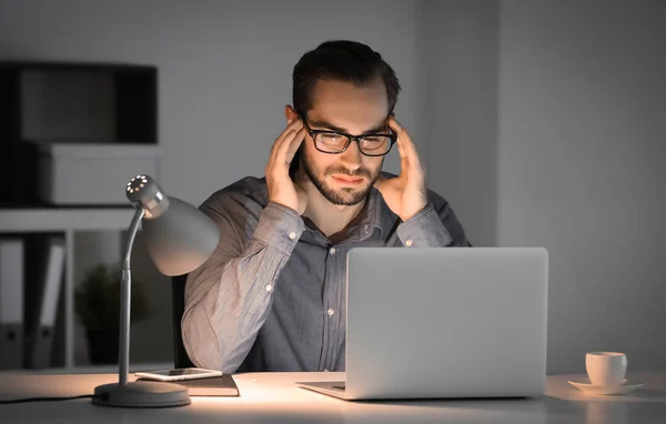 Homem cansado com laptop — Fotografia de Stock