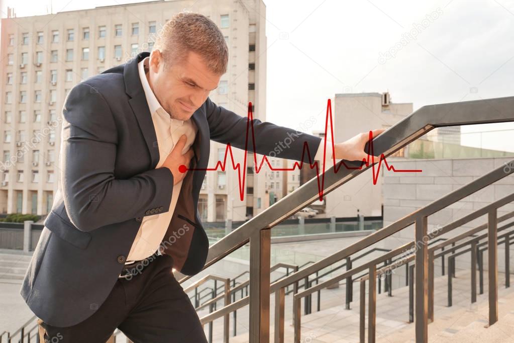 Mature man suffering from heart attack outdoors