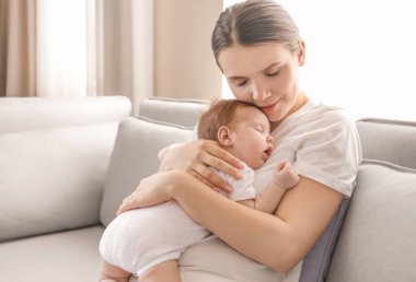 Genç anne holding uyuyan bebek evde