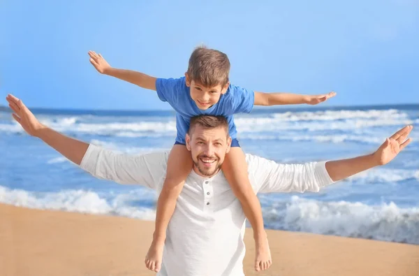 Menino bonito com pai na praia do mar no resort — Fotografia de Stock