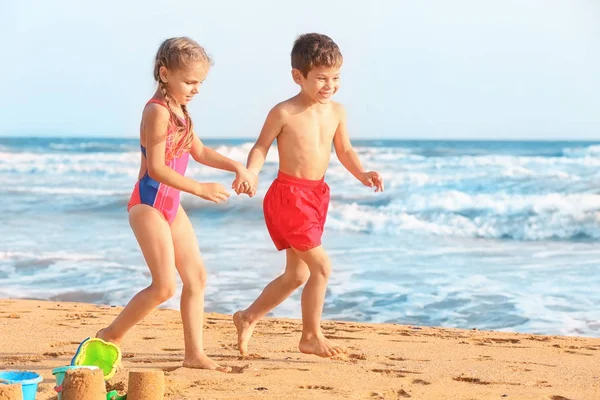 Niedliche kleine Kinder am Meeresstrand — Stockfoto