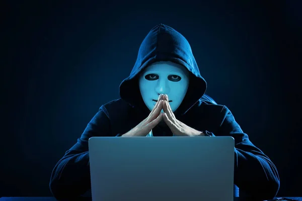 Hacker in mask using laptop — Stock Photo, Image
