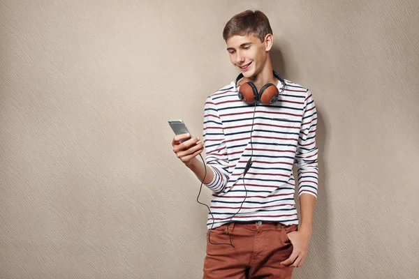 Menino adolescente com fones de ouvido e telefone celular — Fotografia de Stock