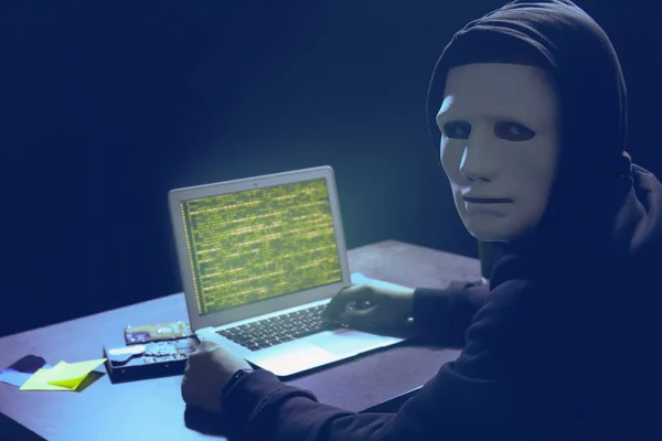 Hacker in maschera con computer portatile — Foto Stock