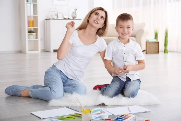 Ibu dengan anak laki-laki lucu melukis gambar di selembar kertas, di dalam ruangan — Stok Foto