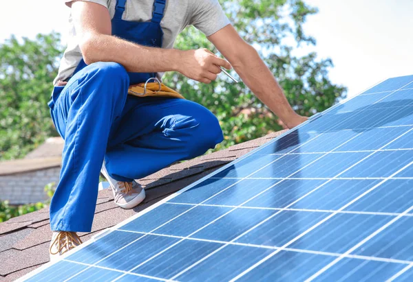 Worker installing solar panels outdoors Stock Picture