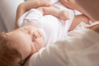 Genç anne holding uyuyan bebek evde