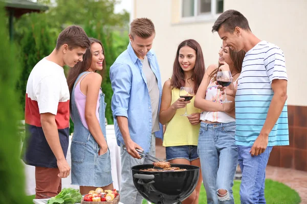 Unge venner har grill fest i haven - Stock-foto